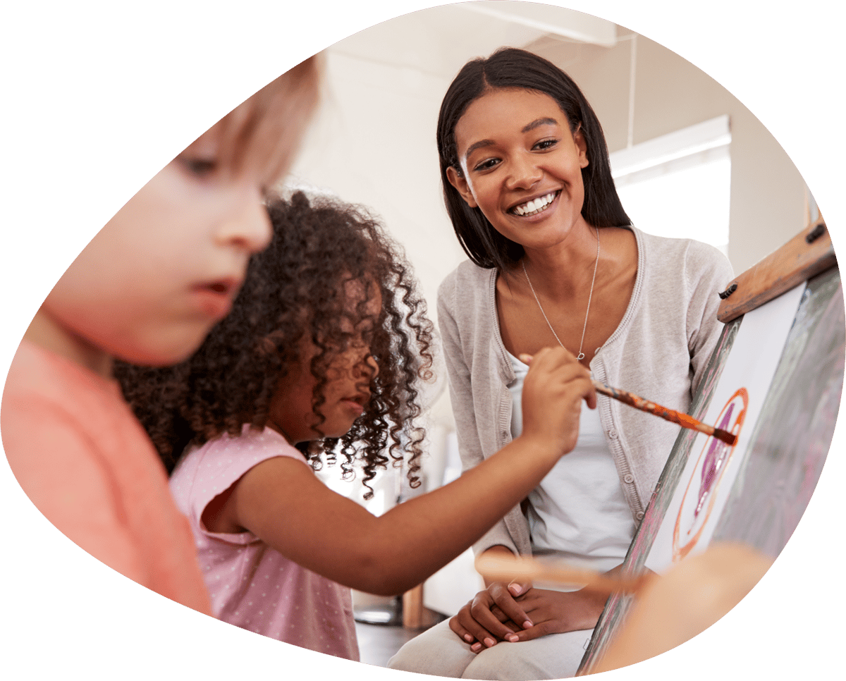 Childcare teacher smiling as her students paint